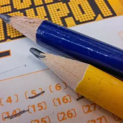 Czy polscy celebryci promujący loterie sami grają w Eurojackpot? Dwa ołówki leżą na kuponie lotto, sugerując wybór liczb.