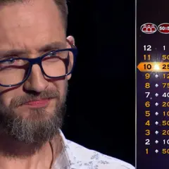 Mężczyzna w okularach na tle drabinki z nagrodami. Wyobraź sobie najgorsze historie osób, które zgubiły zwycięski kupon wart miliony euro.