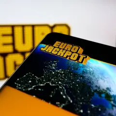 Ekran smartfona z logo Eurojackpot i mapą Europy nocą. Sprawdź eurojackpot wyniki polska!