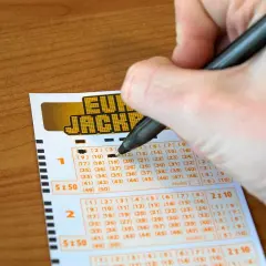 Ręka zaznacza liczby na kuponie Eurojackpot. Zastanawiasz się, dlaczego w Polsce nie można grać w Eurojackpot anonimowo przez pełnomocnika?