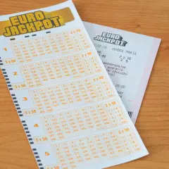 Kupon Eurojackpot na drewnianym blacie. Zastanawiasz się, ile trwa losowanie Eurojackpot? Sprawdź swoje szczęśliwe liczby!