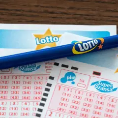 Niebieski ołówek spoczywa na kuponach Lotto. Czy w lotto wygrywa średnio co czwarty kupon? Szansa na wygraną jest zawsze!