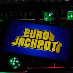 Zielone kostki do gry i ekran telefonu z napisem "EURO JACKPOT" na podświetlanej klawiaturze. Czy to przypadek, dlaczego te same euroliczby wypadły w dwóch losowaniach pod rząd?