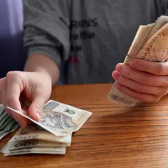 Dłonie liczą polskie banknoty. Zastanawiasz się, jakie dane o użytkownikach zbierają aplikacje pożyczkowe pod pretekstem loterii?