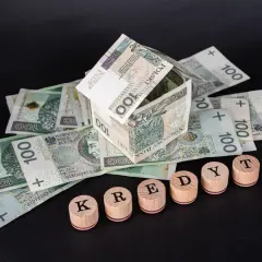 Dom z banknotów 100 zł i drewniane klocki z napisem "KREDYT". Uważaj na najczęstsze błędy w umowach pożyczkowych, które wykluczają z udziału w losowaniu.