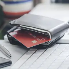 Portfel z czerwoną kartą kredytową na klawiaturze. Dlaczego firmy pożyczkowe wolą oddać samochód w loterii niż obniżyć prowizję o 1%?