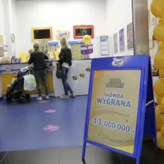 Tablica informacyjna Eurojackpot z kwotą wygranej i żółte balony w punkcie Lotto.