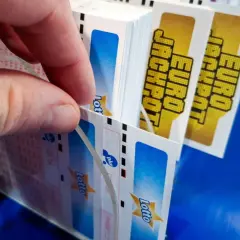 Dłoń wybiera kupony Eurojackpot. Dlaczego w Eurojackpot trudniej trafić siódemkę niż szóstkę w zwykłym Lotto? Więcej liczb do wyboru!