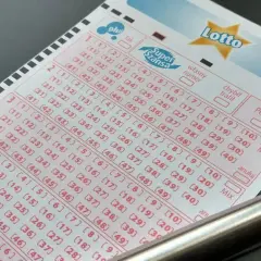Kupon Lotto z polami do zaznaczenia liczb. Czy to właśnie ten kupon przyniesie duży lotek kumulacja? Obok leży metalowy długopis.