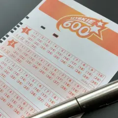 Długopis leży na kuponie lotto "Szybkie 600", gotowy do zaznaczenia liczb. Dowiedz się, jak sprawdzić numery lotto i czy masz szansę na wygraną!