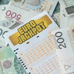 Kupon Eurojackpot na tle polskich banknotów. Czy to wyjaśnia, dlaczego lottomilionerzy z eurojackpot częściej uciekają z polski po wygranej?