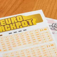 Kupony gry liczbowej Eurojackpot na drewnianym tle.