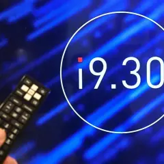 Dłoń z pilotem przed ekranem z godziną 19.30. Czy zmiana godziny emisji programu wpłynęła na oglądalność?