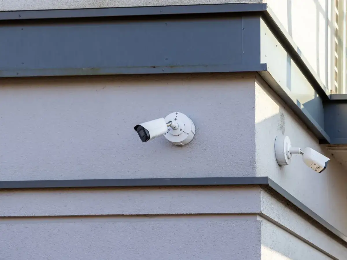 Dwie kamery monitoringu na ścianie budynku. Czy kamery w kolekturach rejestrują twarze osób kupujących zwycięskie kupony?