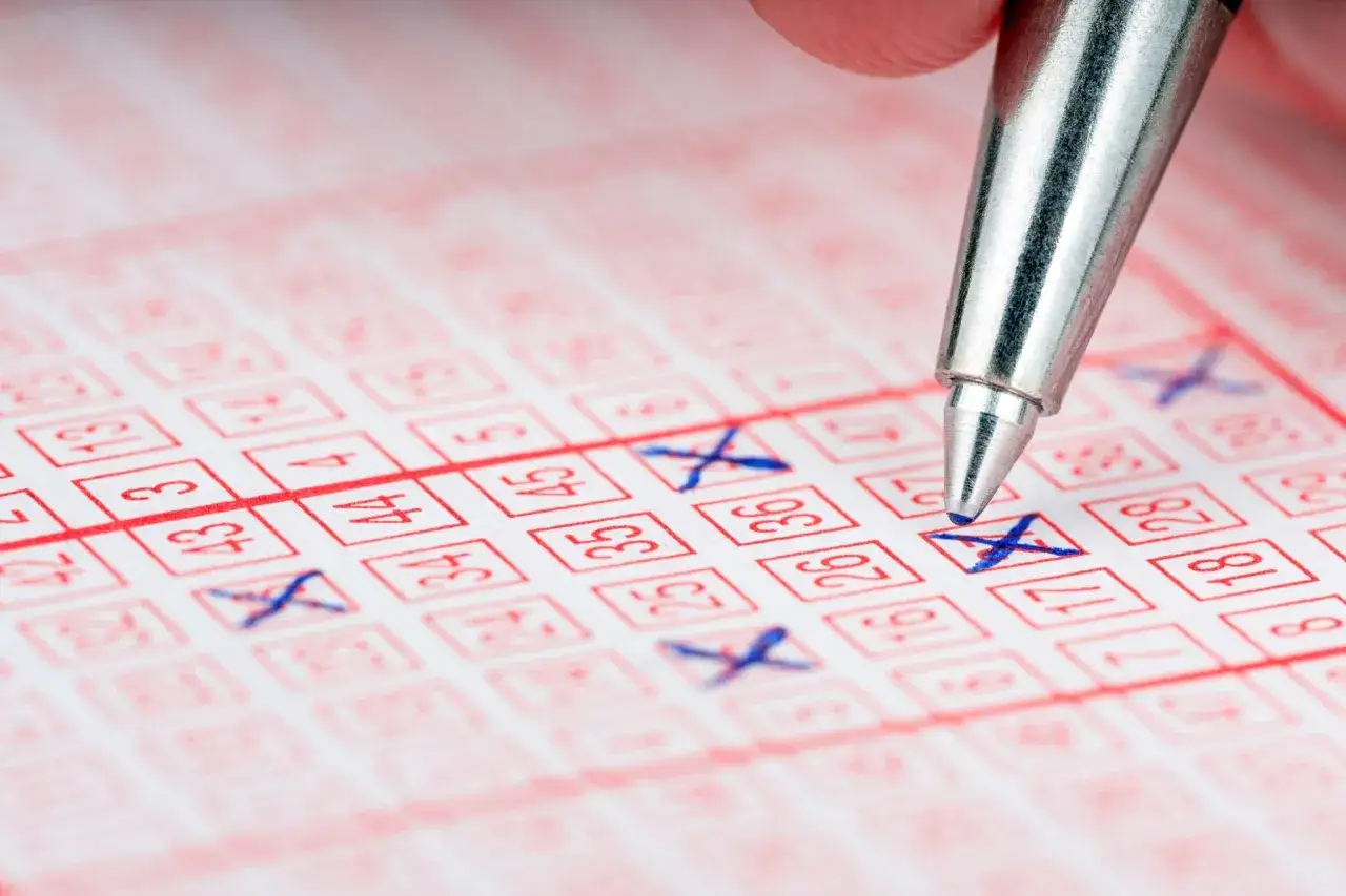 Długopis zaznacza liczby na kuponie lotto, nadzieja na wysokie wygrane.