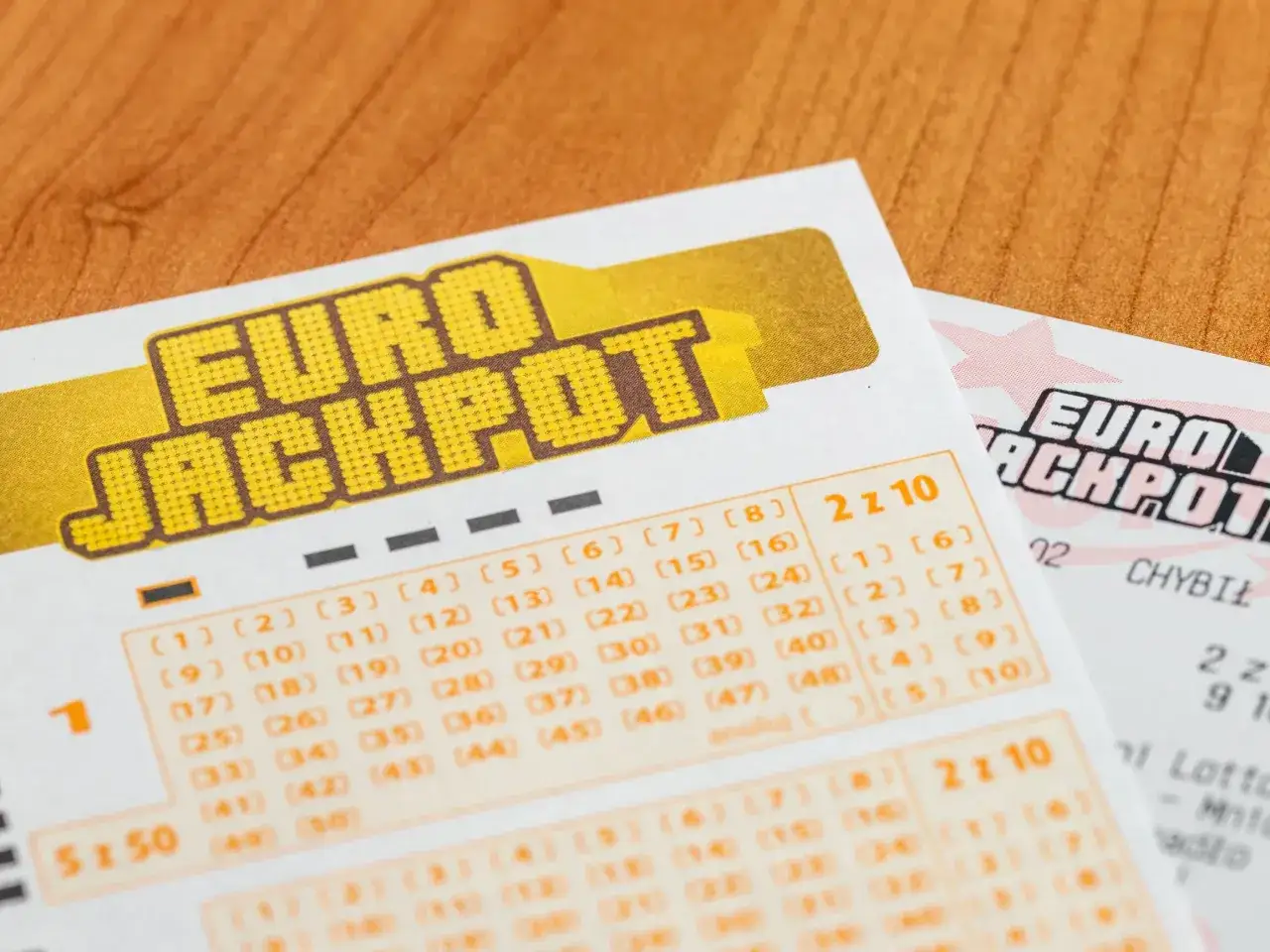 Kupony Eurojackpot na drewnianym blacie. Czy wygrana w Eurojackpot w piątek trzynastego przynosi pecha w życiu?