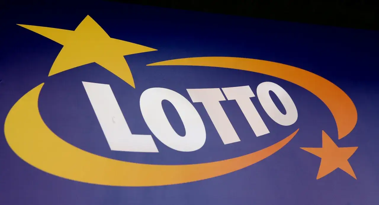 Logo LOTTO na granatowym tle. Czy lottomilionerzy dostają ochronę osobistą od organizatora loterii?