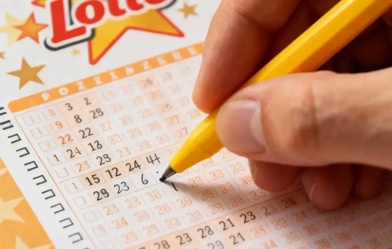Dłoń z żółtym długopisem zaznacza liczby na kuponie Lotto. Dowiedz się, jak sprawdzić numery lotto i czy masz szansę na wygraną.