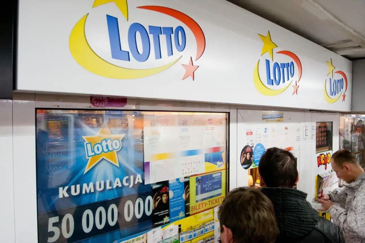 Ludzie stoją przed punktem Lotto, gdzie widnieje informacja o kumulacji 50 milionów. Zastanawiasz się, dlaczego zwycięzcy wielkich kwot w zdrapkach boją się publikować zdjęcia?