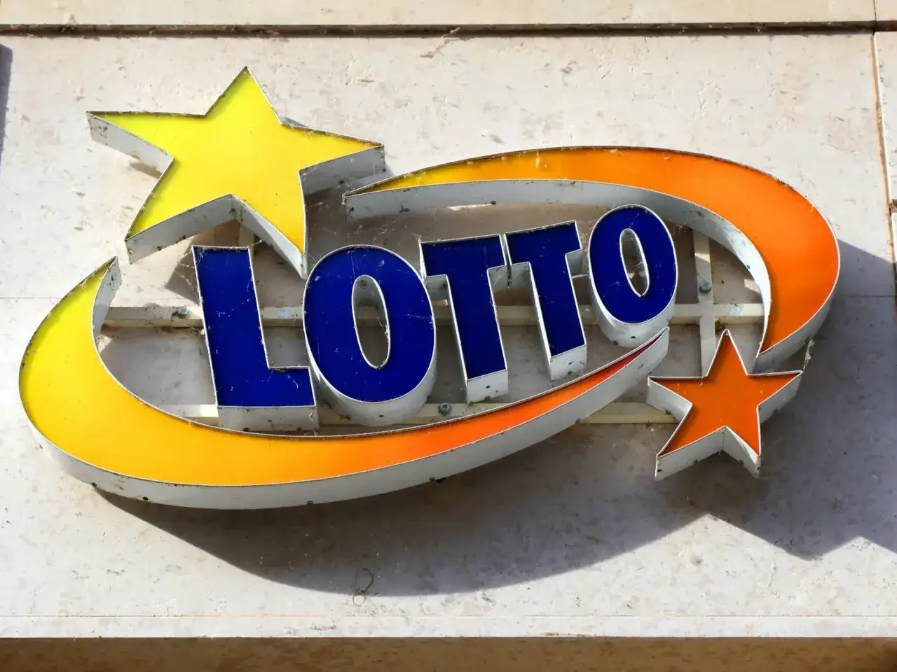 Neonowy napis LOTTO z gwiazdkami. Czy totalizator sportowy blokuje wypłaty wygranych z eurojackpot w Polsce?