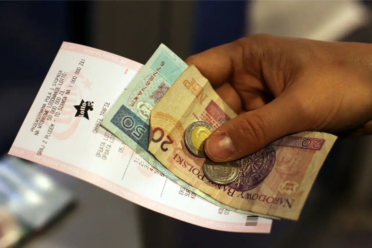 Dłoń trzyma kupon lotto i polskie banknoty. Czy to początek historii o tym, dlaczego zwycięzca 36 milionów ze Skrzyszowa nagle zniknął z okolicy?