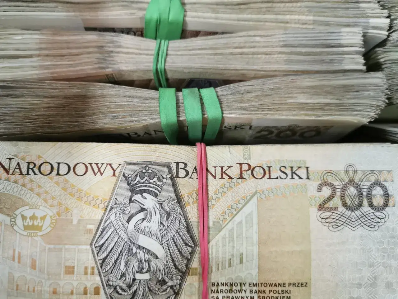 Stosy banknotów 200 zł, jakby właśnie wygrana z lotto online trafiła na konto.