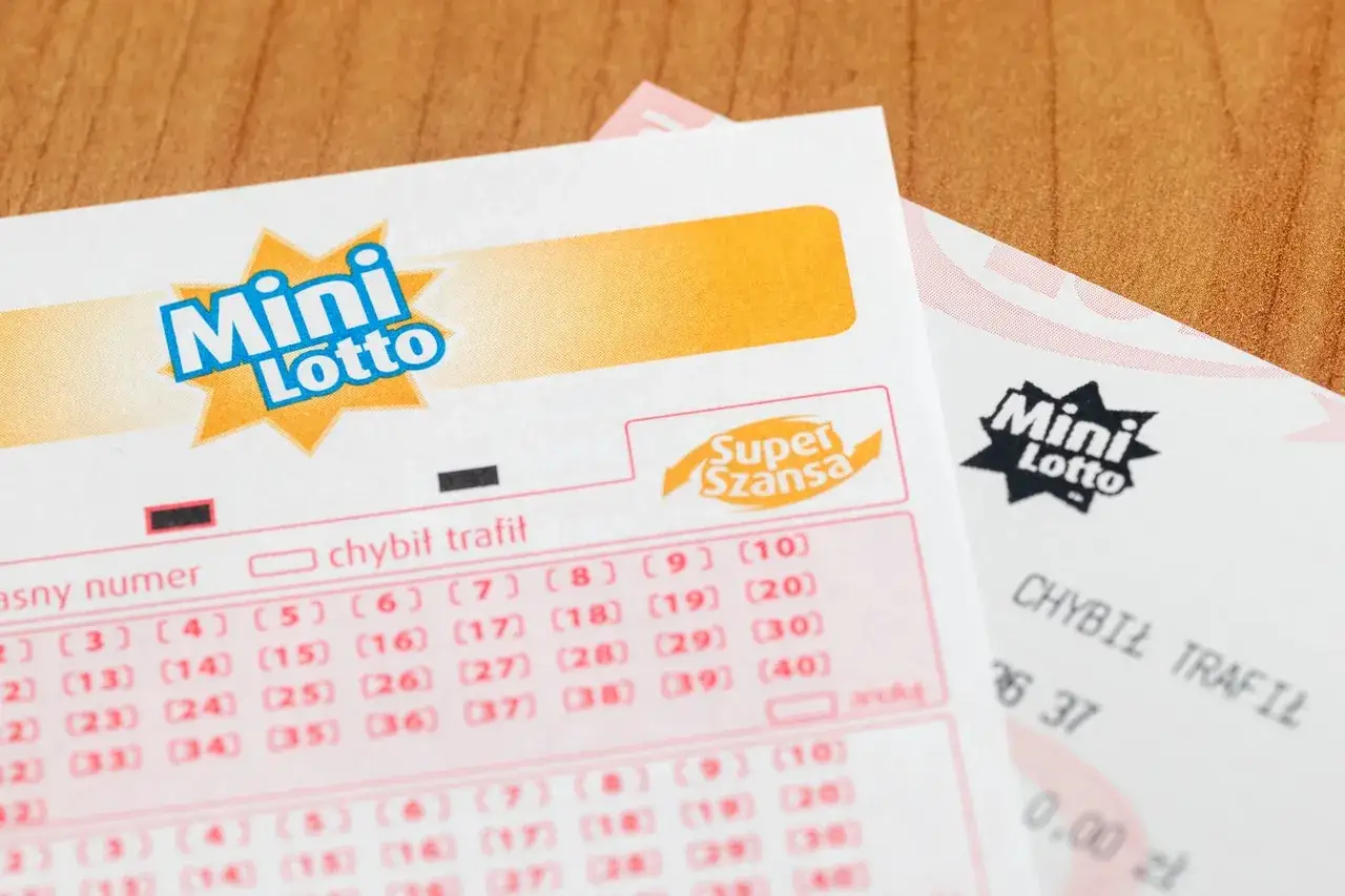 Kupony Mini Lotto leżą na drewnianym blacie. Zastanawiasz się, ile do wygrania w Mini Lotto?