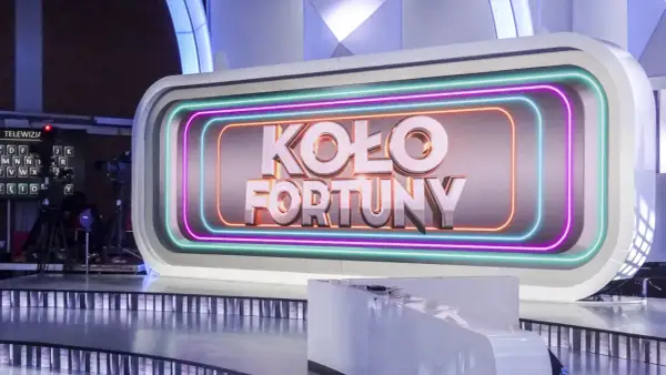 Logo "Koło Fortuny" na tle studia telewizyjnego z neonowym obramowaniem.