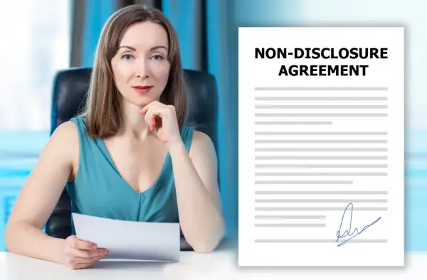 Kobieta z dokumentem w ręku obok umowy o poufności. Czy uczestnicy muszą podpisywać klauzulę poufności dotyczącą wyników przed emisją?