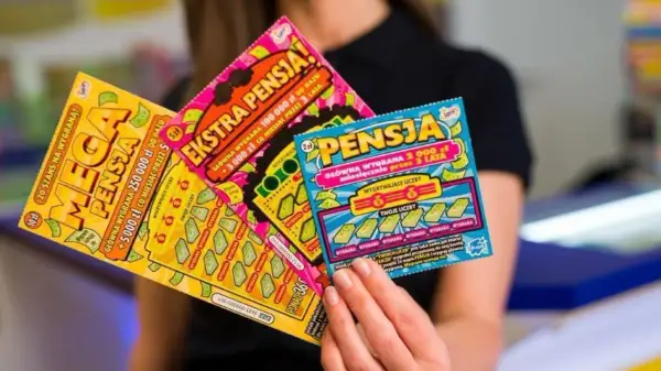 Kobieta trzyma zdrapki lotto: "Mega Pensja", "Ekstra Pensja" i "Pensja". Sprawdź zasady gry, by wygrać ekstra pensję!