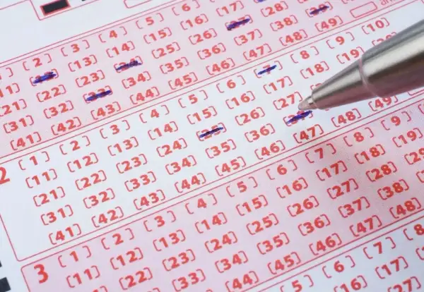 Długopis zaznacza liczby na kuponie lotto. Czy wygrana w zdrapkę online jest tak samo opodatkowana jak ta papierowa?